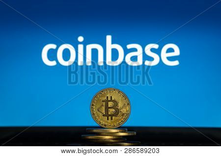 Bitcoin On A Stack Of Coins With Coinbase Logo On A Laptop Screen. Cryptocurrency And Blockchain Ado