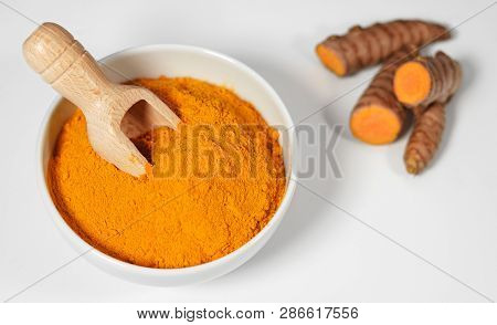 Turmeric Powder And Roots Healthy Spice Asian Food With Sliced Turmeric Roots And Powder In A Bowl W