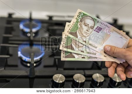 Ukrainian Hryvnia On A Gas Hob With Burning Natural Gas. The Concept Of The Problem Of Gas Transport