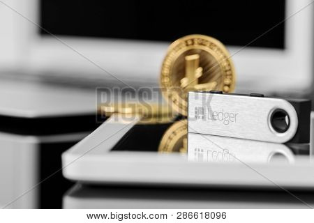 UKRAINE, ROVNO - ON FEBRUARY 26: Ledger Wallet On Laptop for cryptocurrency on a wood background