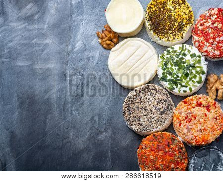 Assortment Of French Fresh White Soft Goat Cheeses With Different Tastes Topping Made With Herbs, Pa