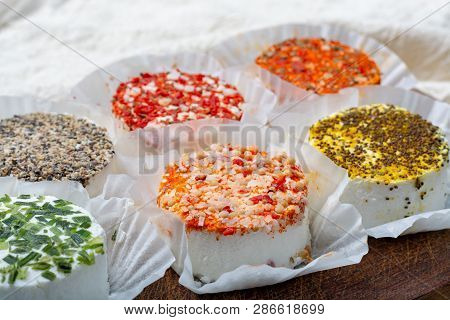 Assortment Of French Fresh White Soft Goat Cheeses With Different Tastes Topping Made With Herbs, Pa