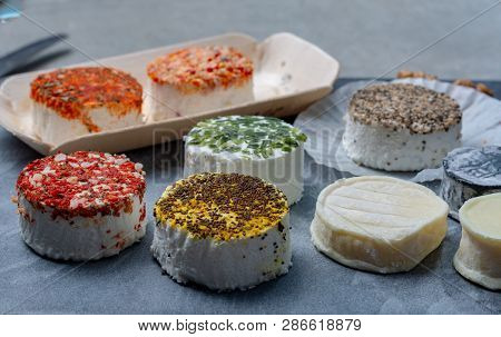 Assortment Of French Fresh White Soft Goat Cheeses With Different Tastes Topping Made With Herbs, Pa