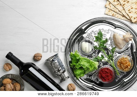 Flat Lay Composition With Symbolic Passover (pesach) Items And Meal On Wooden Background, Space For 