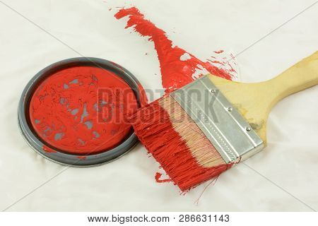 Afterwards Of Painting With Paint Can Lid And Paintbrush Covered With Red Paint On White Plastic Wit
