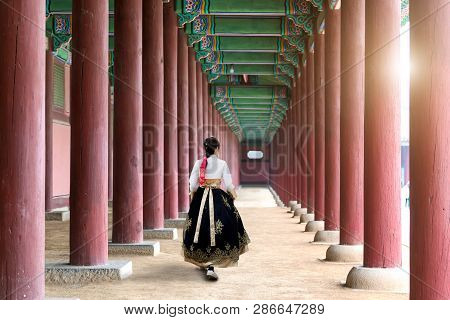 Asian Korean Woman Dressed Hanbok In Traditional Dress Walking In Gyeongbokgung Palace In Seoul, Sou