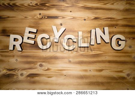 RECYCLING word made with building blocks on wooden board