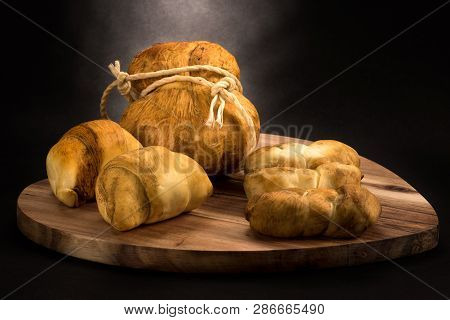 Various Types Of Smoked Cheese On A Black Background