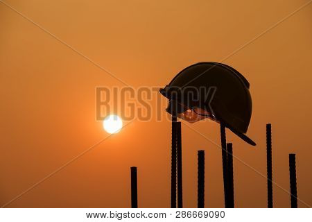 Silhouette of safety helmet ,helmet in construction site and sunset,Safety helmets for workplace con