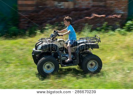 The Boy Is Traveling On An Atv.