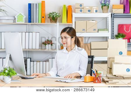 Young Beautiful, Attractive Asian Businesswoman With Pony Tail, White Shirt, Sitting In Front Of Com