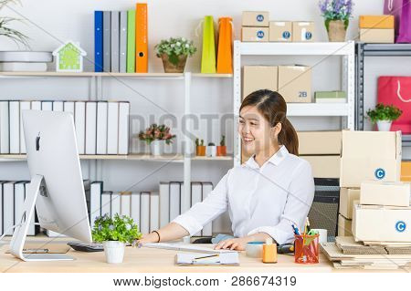 Young Beautiful, Attractive Asian Businesswoman With Pony Tail, White Shirt, Sitting In Front Of Com