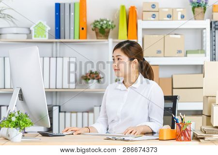 Young Beautiful, Attractive Asian Businesswoman With Pony Tail, White Shirt, Sitting In Front Of Com