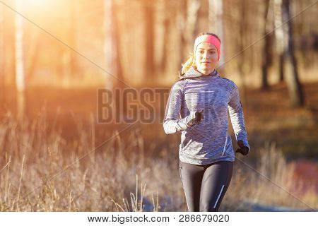 Young Girl Running In The Park In Early Winter