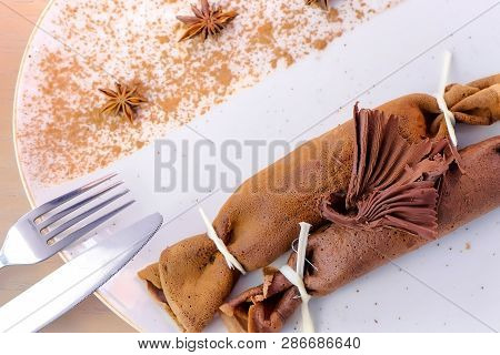 Chocolate Russian Pancakes, Blini With Curd Filling On The Plate. Served With A Chocolate Figure. Cl