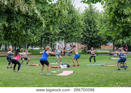 Moscow, Museon Park, July 14, 2018: Group Of Man And Women In Sportswear Doing Physical Exercises Wi