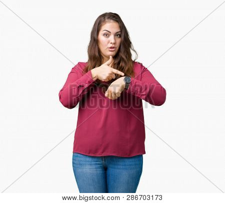 Beautiful plus size young woman over isolated background In hurry pointing to watch time, impatience, upset and angry for deadline delay