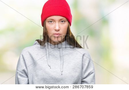 Young caucasian beautiful woman wearing wool cap over isolated background with serious expression on face. Simple and natural looking at the camera.