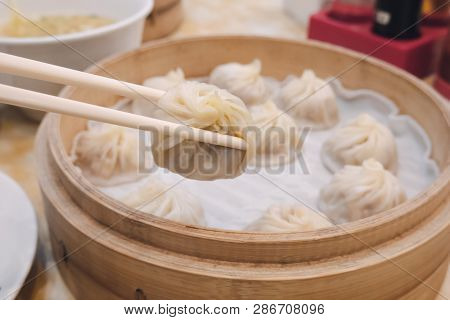 Xiao Long Bao Soup Dumpling Buns With Chopsticks In Restaurant (traditional Chinese Food) In Taipei 