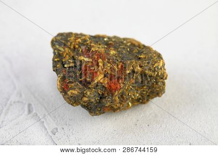 Natural Mineral Rock Specimen - Raw Stone Orpiment On White Cement Background From Haidarkan, Kyrgyz