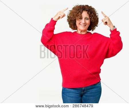 Beautiful middle ager senior woman red winter sweater over isolated background Smiling pointing to head with both hands finger, great idea or thought, good memory