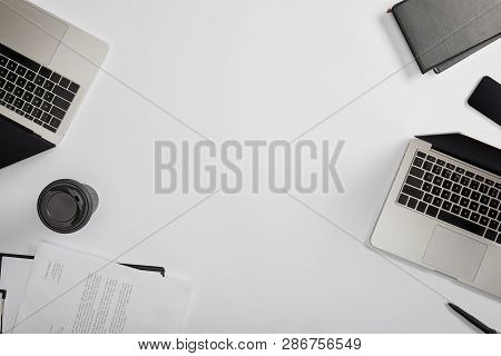 Top View Of Documet On Clipboard, Paper Cup, Laptops, Pen, Notebooks