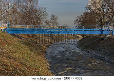 Blue Pipes Over Bilina River In Bilina Town In Winter Sunny Morning