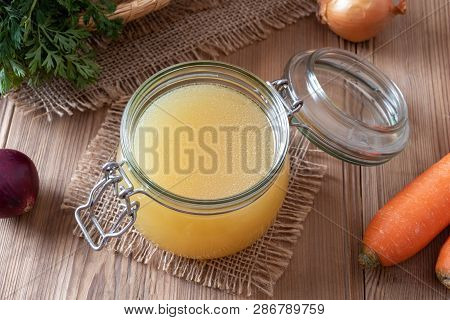 Chicken Bone Broth In A Glass Jar And Fresh Vegetables