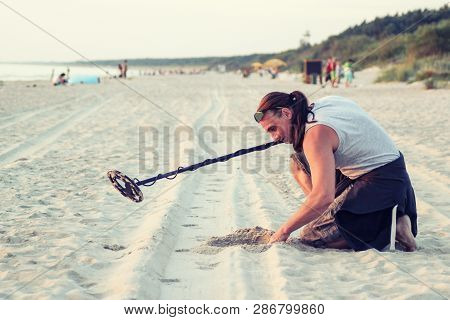 Man Use Metal Detector On The Beach