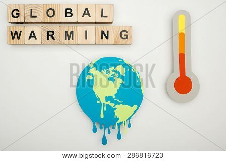 Paper Cut Melting Earth, Wooden Cubes With Global Warming Lettering, And Thermometer With Hign Tempe