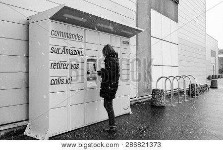Strasbourg, France - Feb 8, 2018: Side View Of Young Woman Using Amazon Locker The Self-service Parc