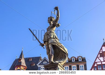 Lady Justice Standing At The Fountain Under Blue Sky In Frankfurt As A Symbol Of Justice