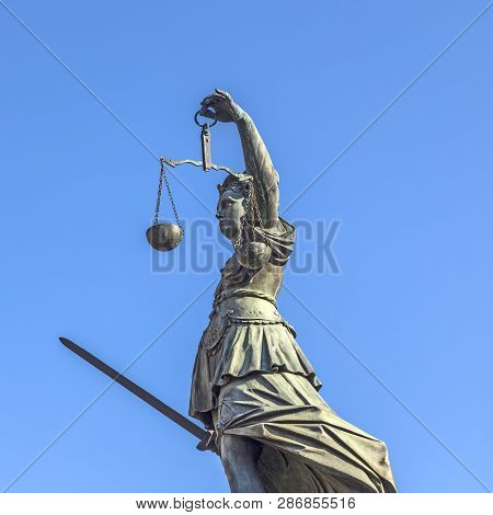 Lady Justice Standing At The Fountain Under Blue Sky In Frankfurt As A Symbol Of Justice