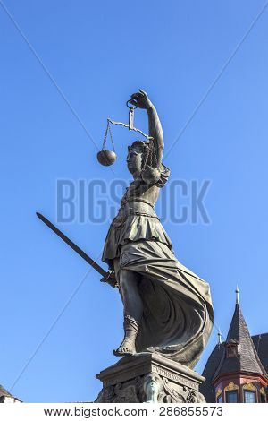 Lady Justice Standing At The Fountain Under Blue Sky In Frankfurt As A Symbol Of Justice