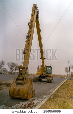 Excavator On The Road With Sky In The Background