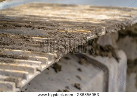 Grousers Of An Excavator With Soil Between Bars