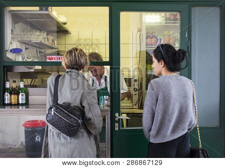 Vienna, Austria - May, 22: A Couple Of Friend Waiting A Hot Dog In Typical Viennese Fast Food Snack 