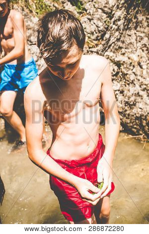 Young Boys Have Fun At The Small River - Outdoor Summer Activities - Fun In The Nature Concept