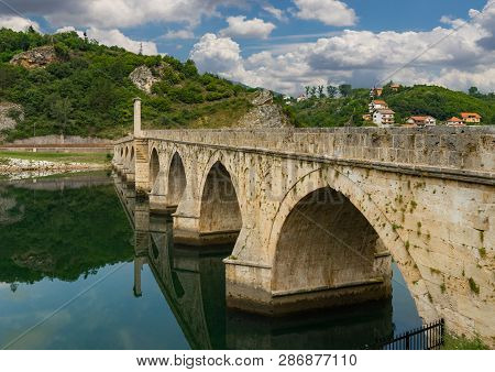 The Ottoman Mehmed Pasa Sokolovic Bridge In Visegrad, Bosnian Mountains, With Fantastic Sky Scape An