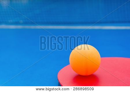 Pingpong Racket And Ball And Net On A Blue Pingpong Table