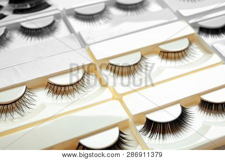 Set With Different False Eyelashes In Packs As Background, Closeup
