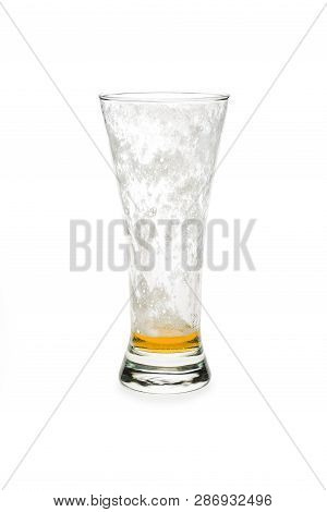 Almost Empty Pilsner Beer Glass Isolated Against White Background.