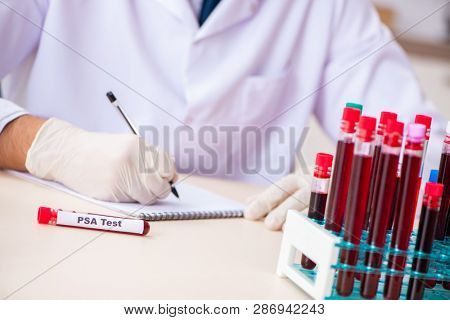 Young handsome lab assistant testing blood samples in hospital 