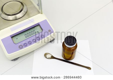 Laboratory Scale On Table With Materials In Bottle.