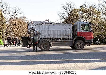 Varna, Bulgaria, February 28, 2019. The Garbage Truck Operator Controls The Emptying Of The Garbage 