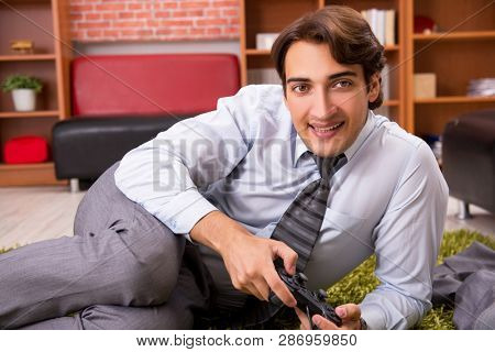 Young employee playing joystick games during his break 