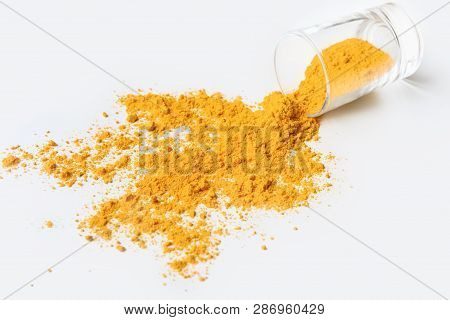 Glass Jar With Turmeric Powder Scattered On White Background