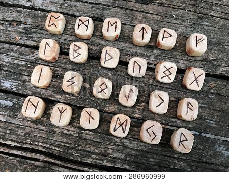 A Stack Of Wooden Runes At Forest. Wooden Runes Lie On A Old Wood Background. Runes Are Cut From Woo