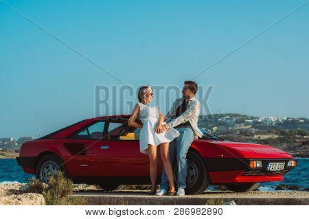 Young Couple Near The Red Ferrari