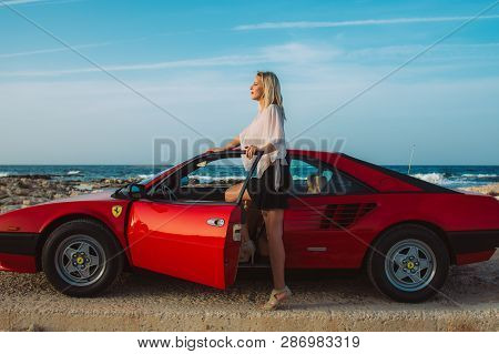 Young Beautiful Girl Posing Near The Red Ferrari